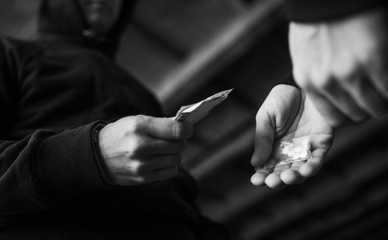 drug trafficking, crime, addiction and sale concept - close up of addict with money buying dose from dealer on street